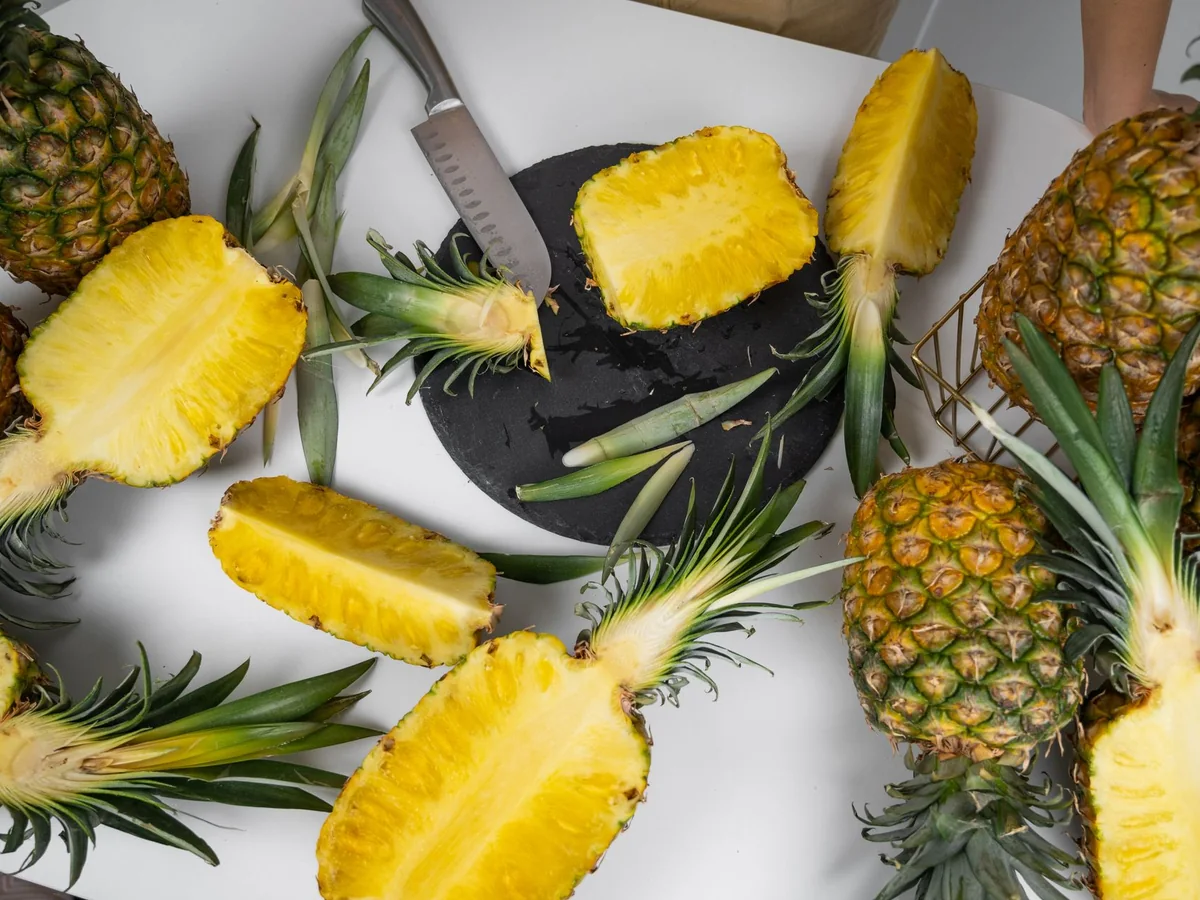 Fresh pineapples halved and sliced on a table